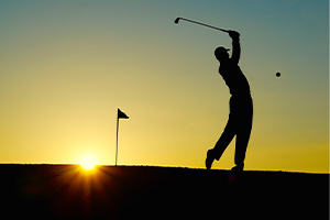 Ein Golfer als schwarze Silhouette im Gegenlicht
