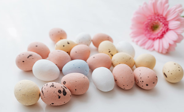 Mehrere pastellfarbene Ostereier mit dunklen Sprenkeln