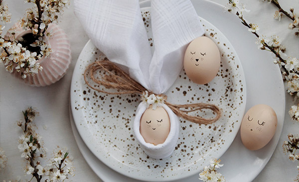 Niedliche Ostereier mit kleinen gesichtern liegen auf einem Teller